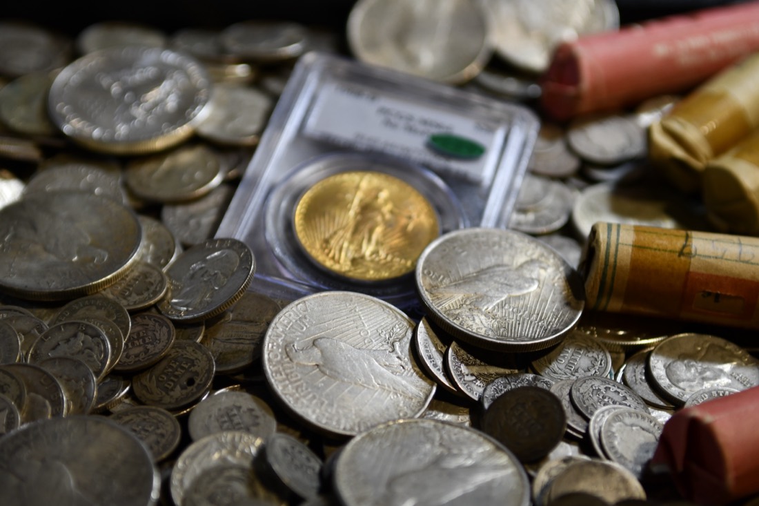 Gold Double Eagle in a graded slab among silver coins